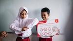 Anak-anak berlatih mencuci tangan di lingkungan kelas.